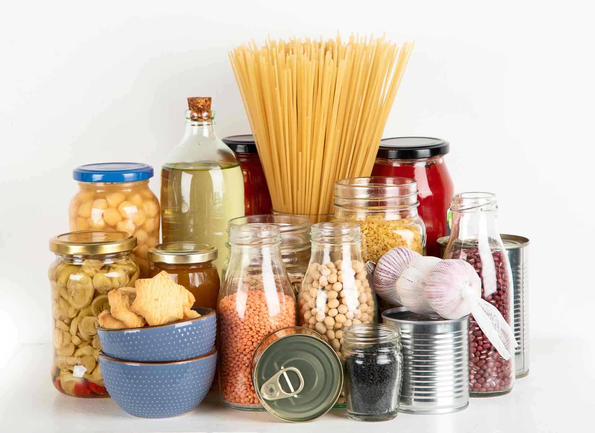 A variety of shelf-stable foods, including jars of lentils, beans, pasta, and canned goods, ideal for emergency food storage.