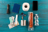 An assortment of vital survival items including a flashlight, water, medication, and other essentials, key for bartering during crisis situations.