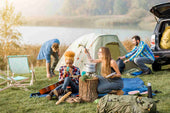 A group of campers cooking and enjoying gluten-free freeze-dried meals near a tent by the lake. Lightweight and easy-to-prepare food options perfect for outdoor adventures and emergency situations.